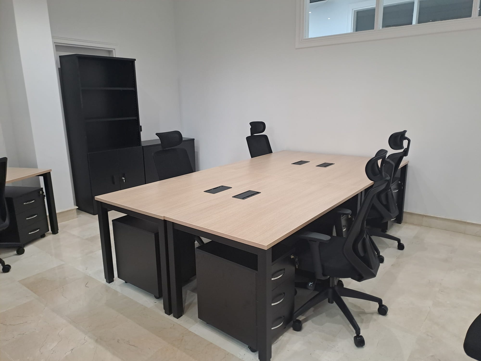 Oficina con mesa, sillas y cajoneras